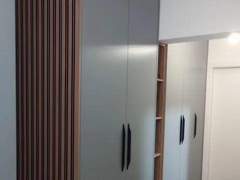 Sivi ormar s crnim ručkama